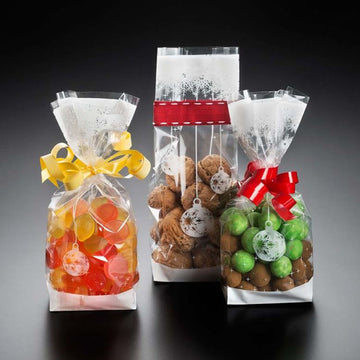 Sacchetti di Natale, trasparenti, con grafiche bianche. ripieni di caramelle e noci